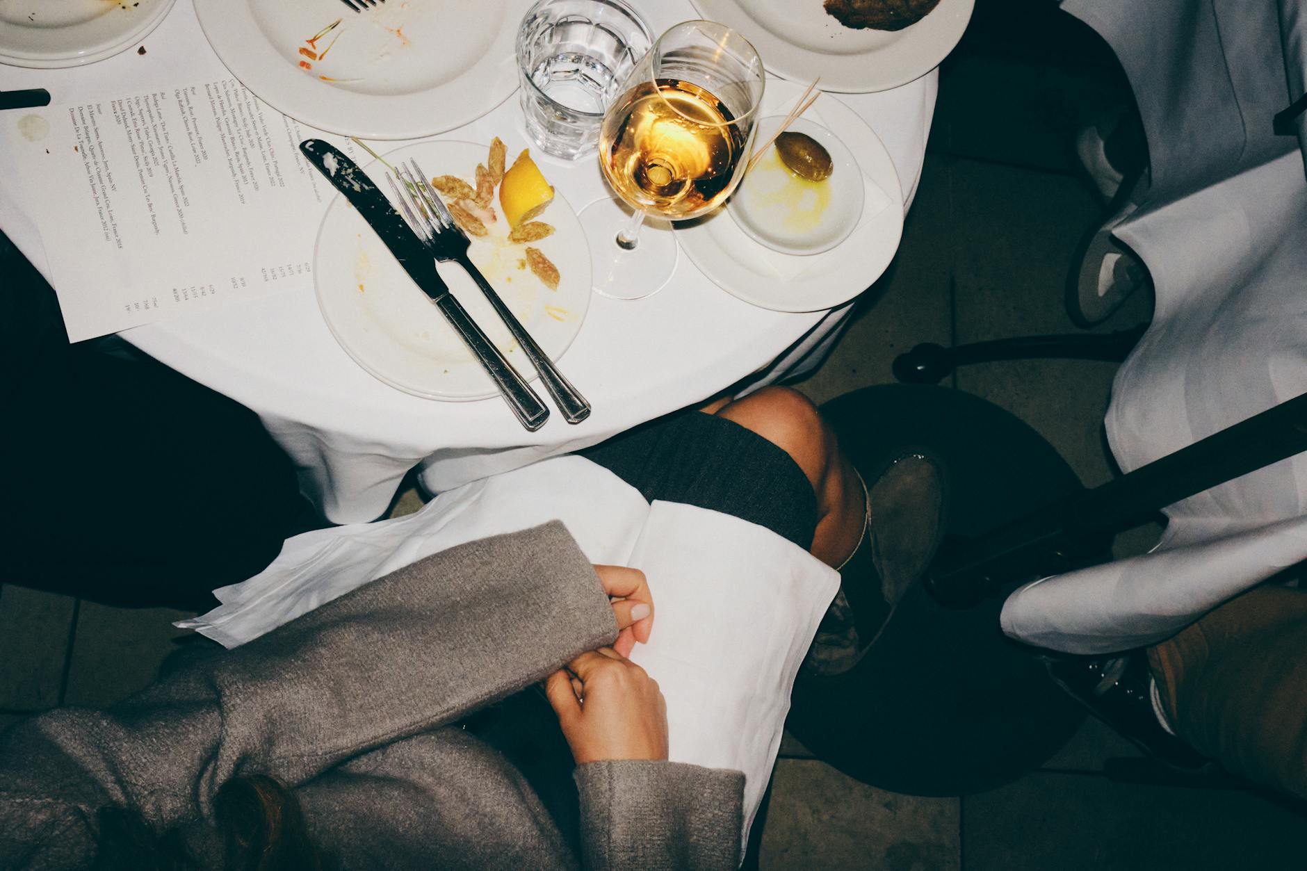 Wine glass next to a meal, illustrating food and wine pairing