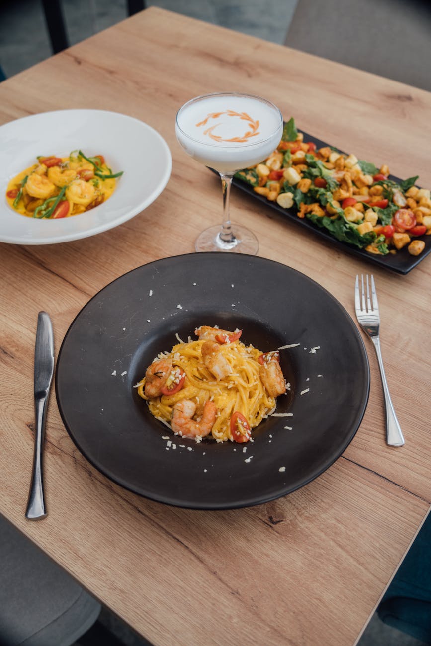Close-up of a whisk stirring a creamy sauce in a bowl.